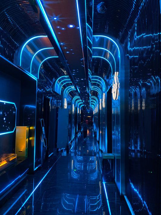 Futuristic corridor with LED lighting in a high-end entertainment venue, showcasing the importance of soundproof and fire-resistant door integration for safety and privacy.
