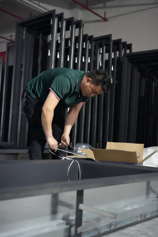 Factory technician assembling internal wiring of a custom soundproof door, highlighting craftsmanship and quality control behind every order