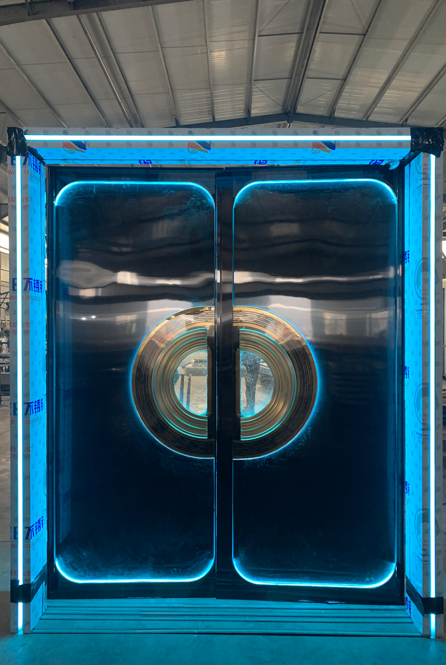 Sleek double stainless steel soundproof door with blue LED lighting and central circular glass window – perfect for clubs and entertainment venues
