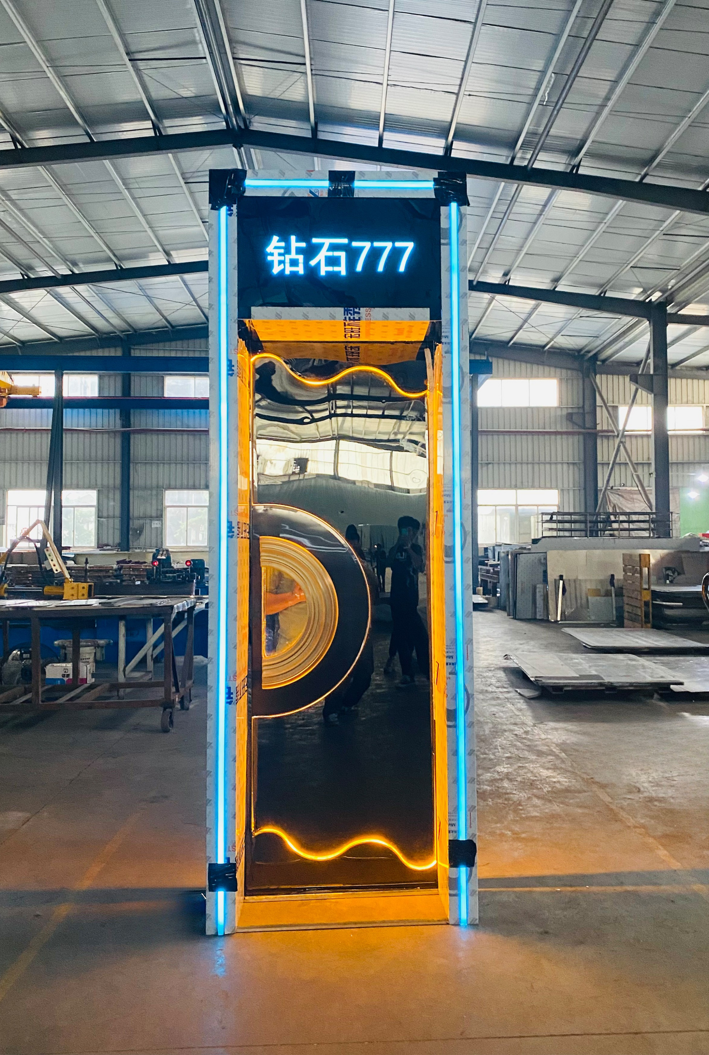Stainless steel LED soundproof door with circular window, wave-shaped amber lighting, and illuminated custom text – perfect for KTV or club entrances