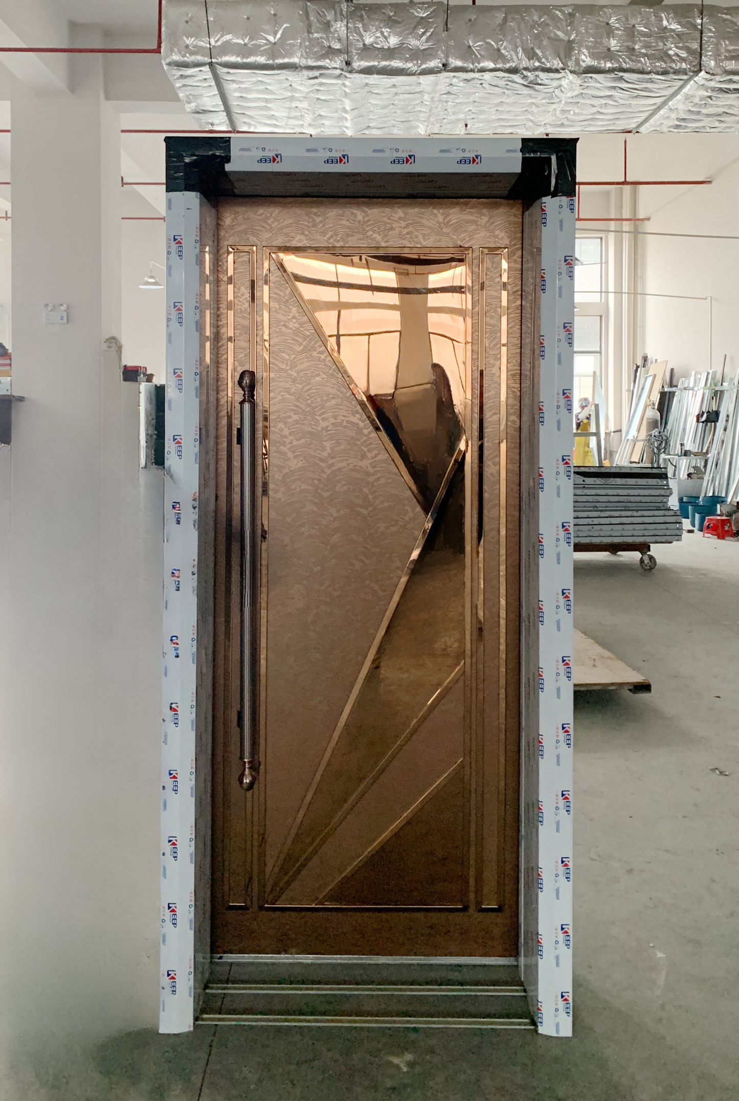 Bronze flat soundproof door with geometric triangular design and long vertical handle