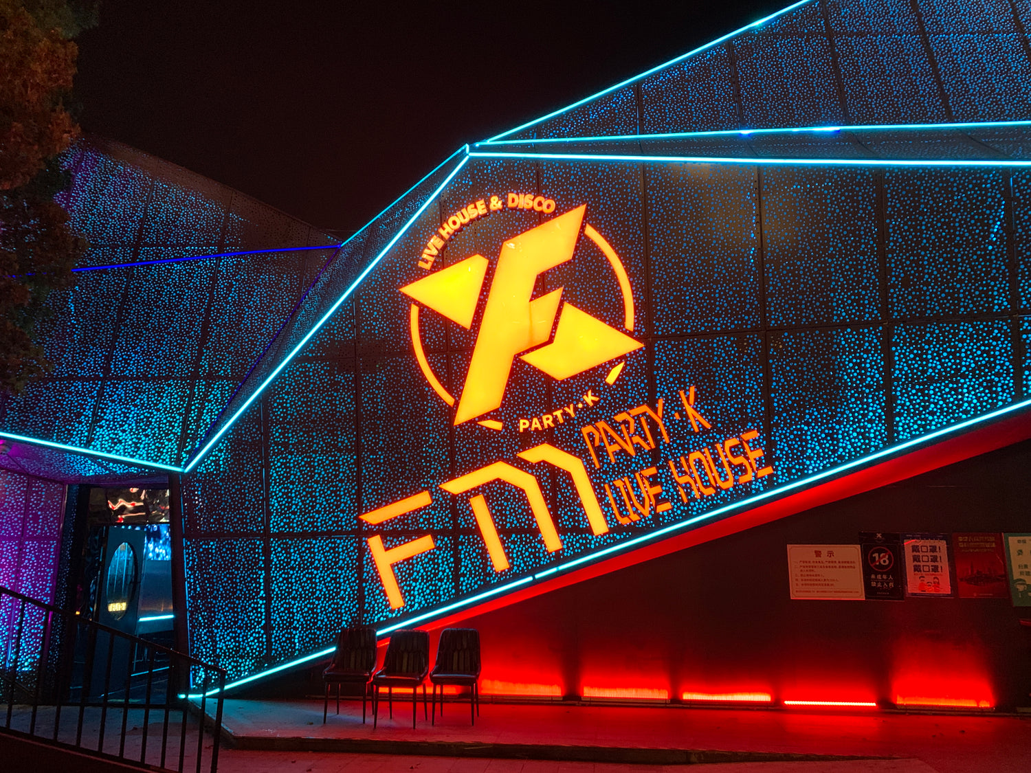 The exterior of a Southeast Asia KTV venue featuring vibrant lighting and branding, showcasing the use of China-made soundproof doors for enhanced party experiences.