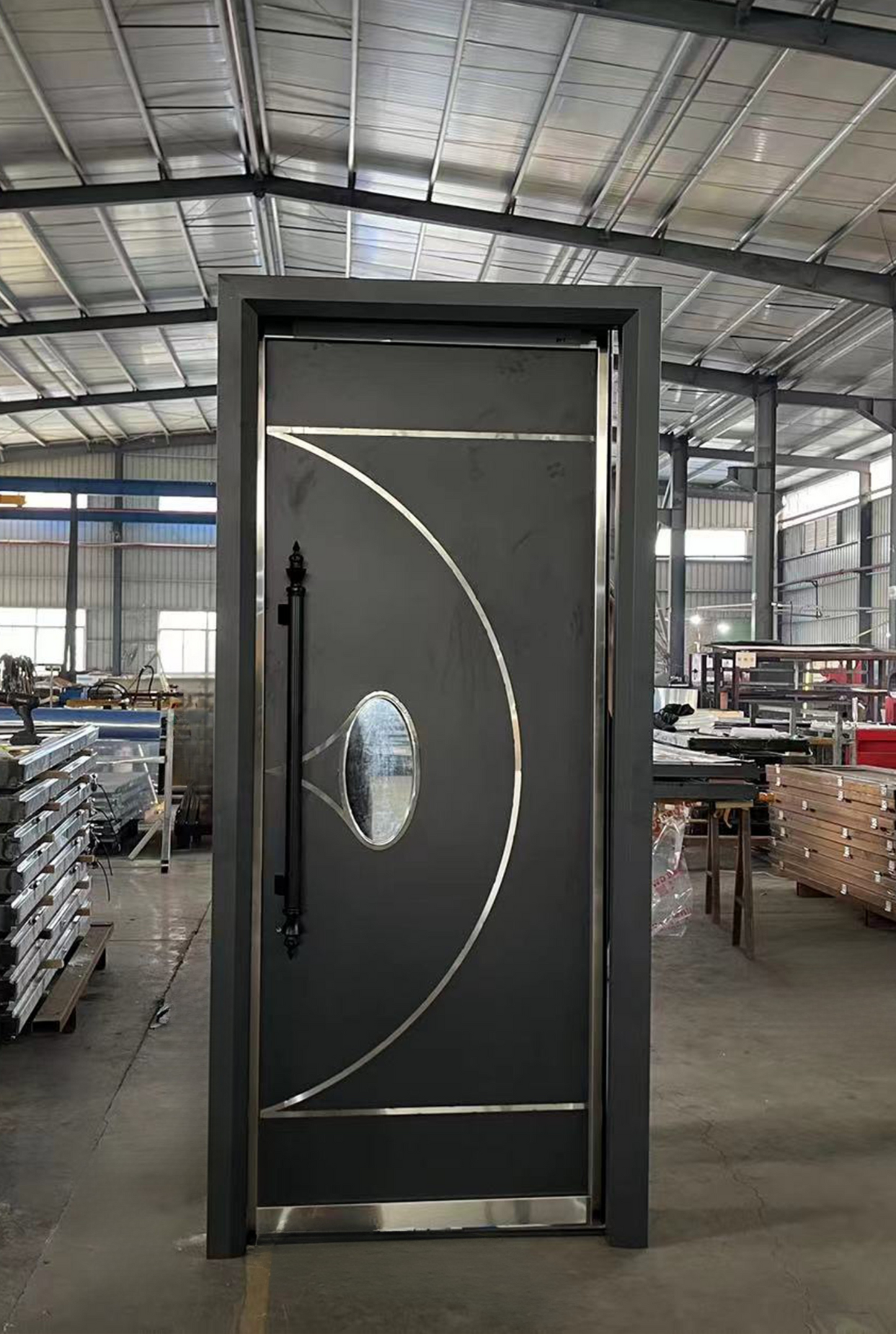 Flat black soundproof door with curved silver inlays and an oval glass window – sleek modern style