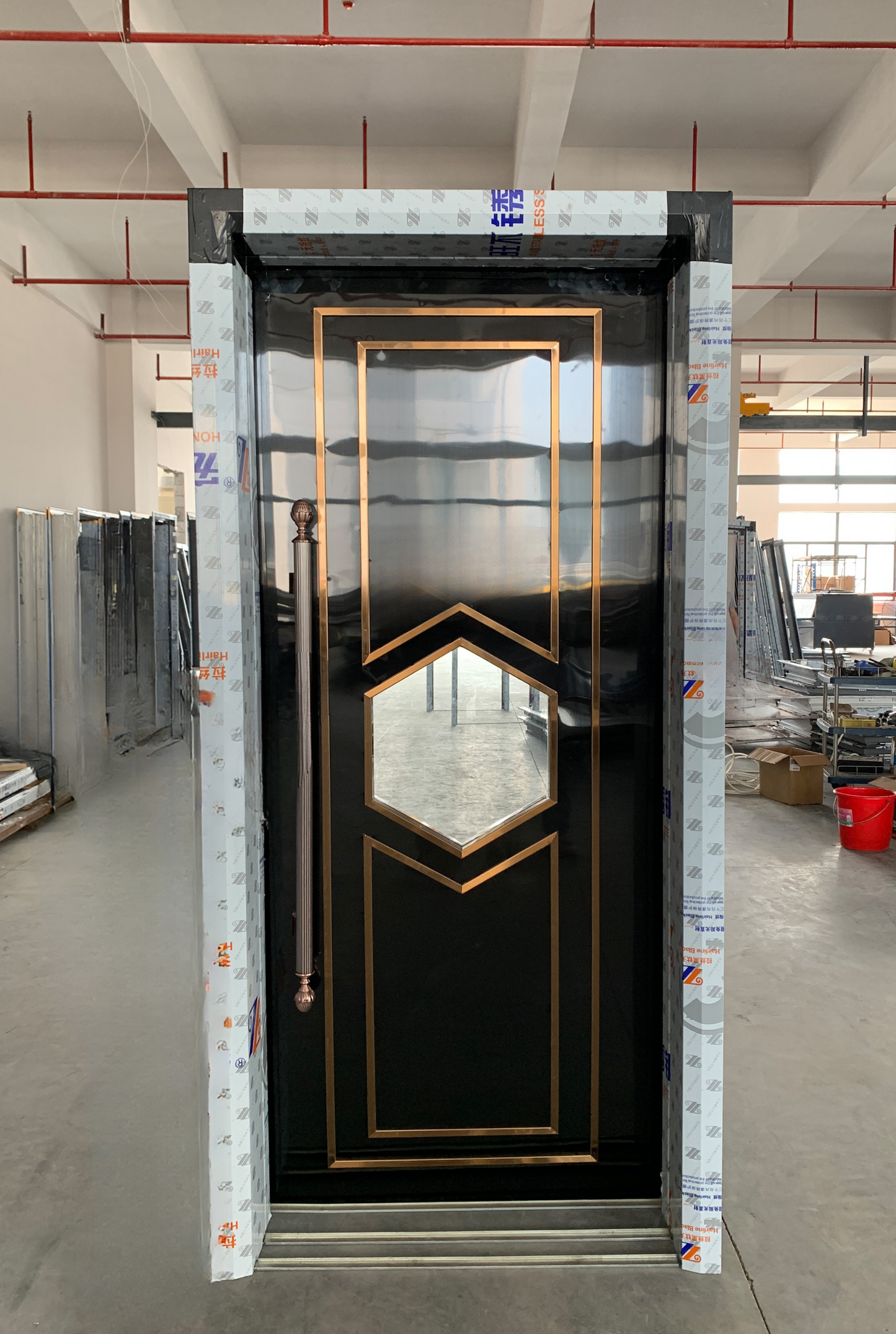 Black flat soundproof door with bronze frame and diamond-shaped glass window – elegant and bold design