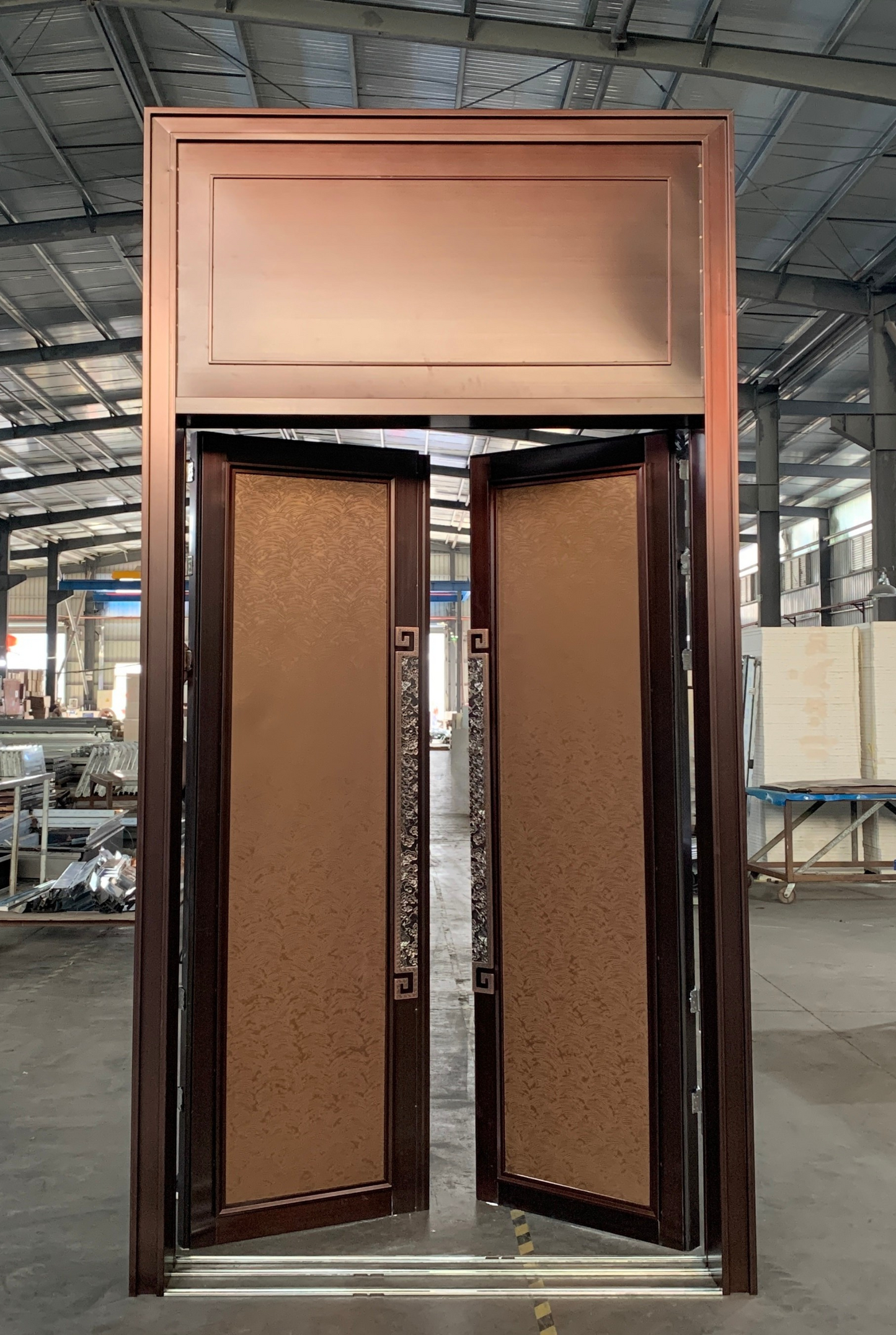 Folding bronze flat soundproof door with decorative inlays and traditional patterns