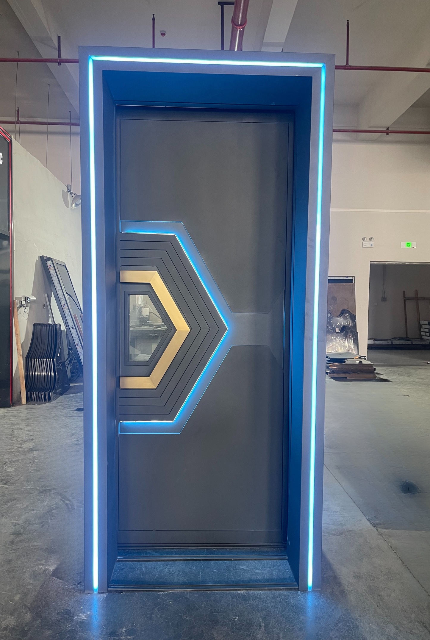 Gray stainless steel soundproof door with layered geometric arrow design, blue LED outline, and central window – ideal for modern KTV or club spaces
