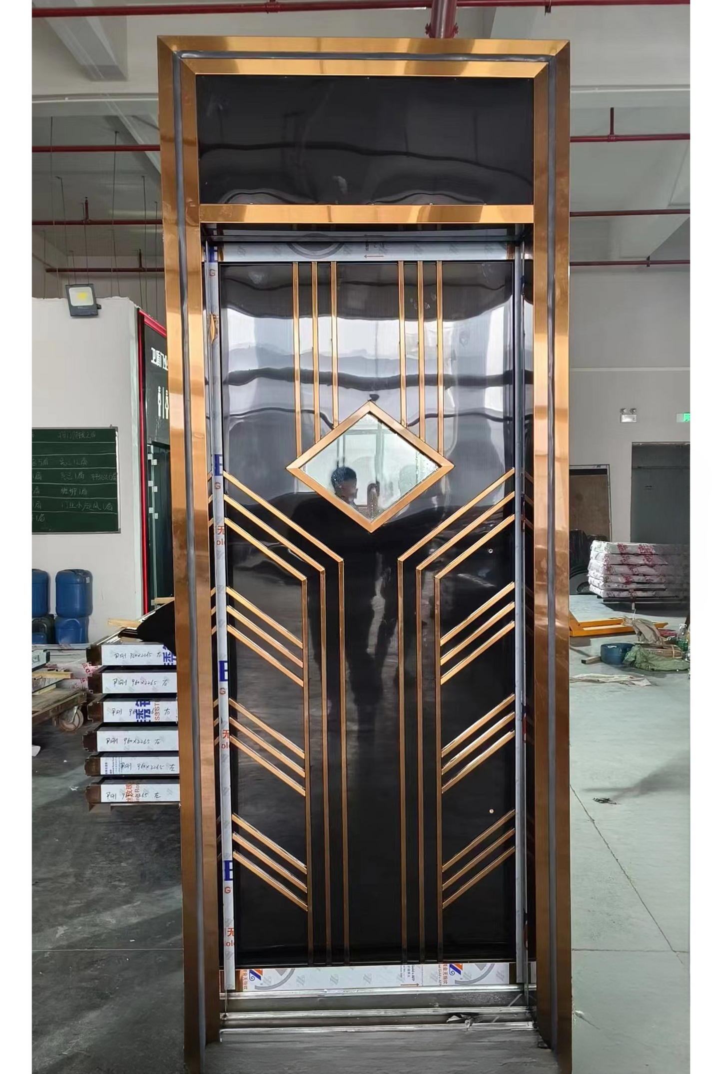 Black stainless steel soundproof door with golden Art Deco lines and a central diamond-shaped window, designed for stylish entertainment venues.